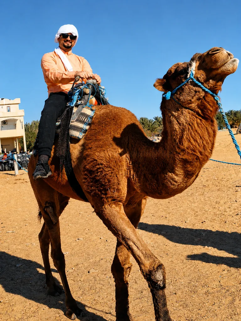 A man riding a camel in Tunisia under a clear blue sky